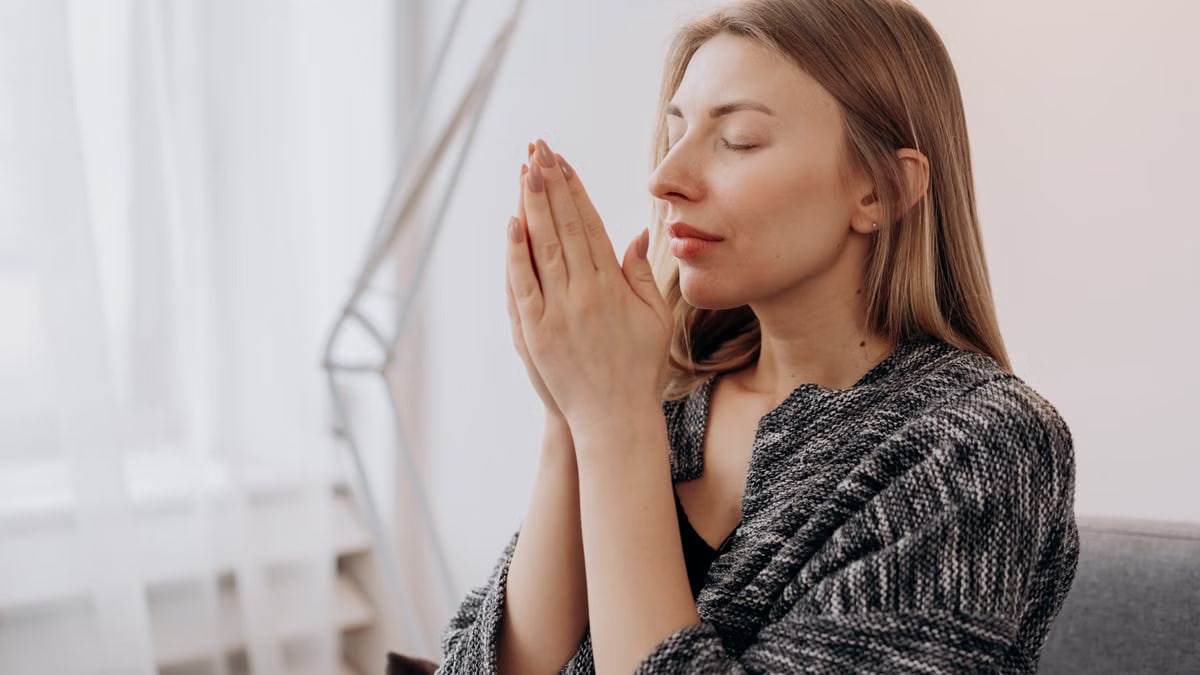 A serene woman practicing meditation indoors for relaxation and wellness.